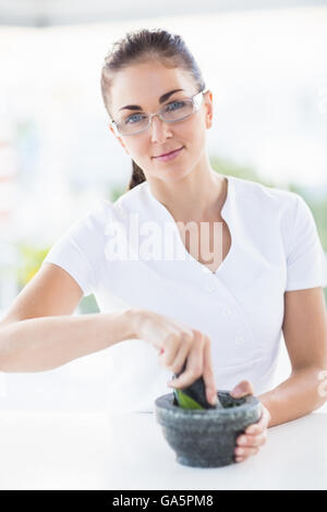 Portrait of woman holding mortar and pestle Stock Photo