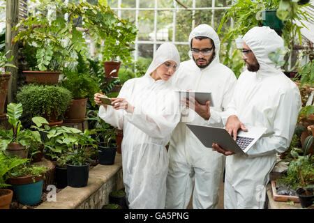 Scientists discussing over technologies at greenhouse Stock Photo