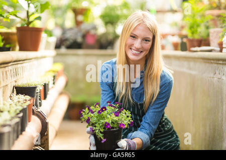 Happy young woman holding flowering plant Stock Photo