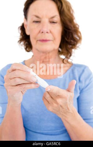 Diabetic woman using blood glucose monitor Stock Photo