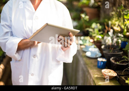 Midsection of scientist using digital tablet Stock Photo