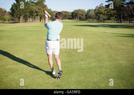 Rear view of golfer taking shot Stock Photo