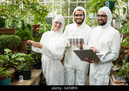 Happy scientists in clean suit using technologies Stock Photo