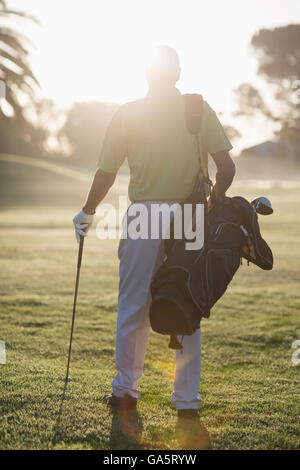 Full length Rear view of man carrying golf bag Stock Photo