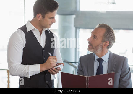 Waiter taking the order from a businessman Stock Photo