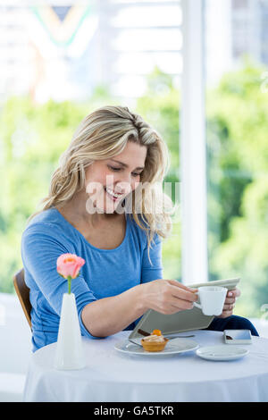 Smiling mature woman using digital tablet Stock Photo
