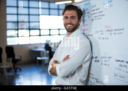 Confident businessman leaning on whiteboard Stock Photo