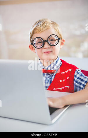 Portrait of schoolkid using laptop in classroom Stock Photo