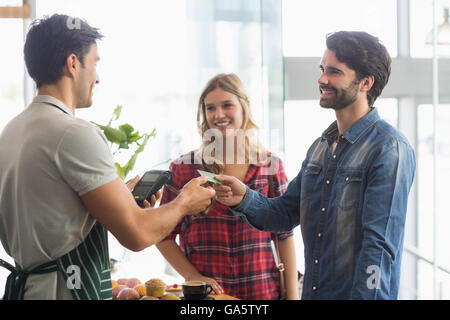 Couple paying bill at coffee shop using card bill Stock Photo
