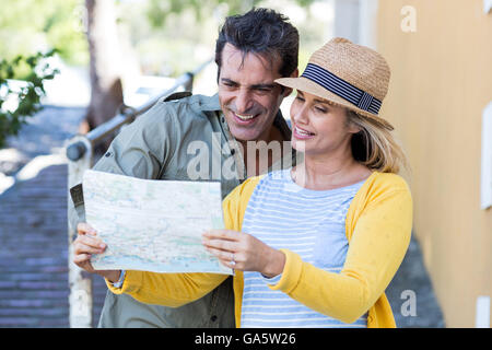 Couple looking in map while standing on walkway Stock Photo