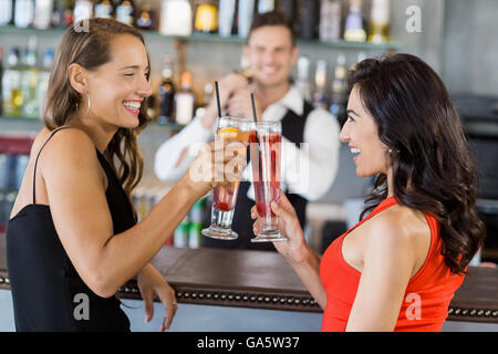 Beautiful women toasting cocktail glasses Stock Photo