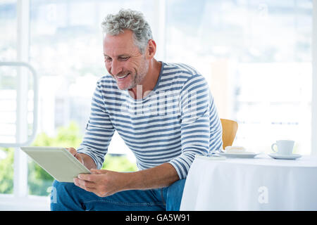 Smiling mature man using digital tablet Stock Photo