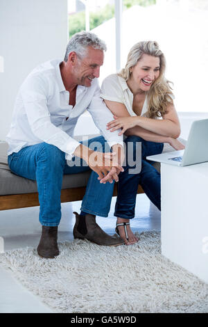 Smiling mature couple using laptop Stock Photo