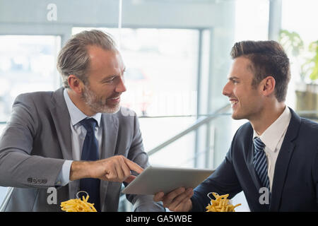 Businessmen using digital tablet in restaurant Stock Photo