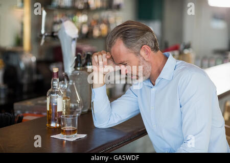 Tired man leaning his elbow on the counter Stock Photo