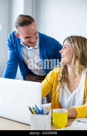 Happy colleagues talking in office Stock Photo