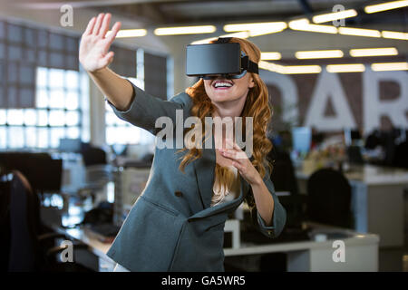 Cheerful woman using virtual reality simulator Stock Photo