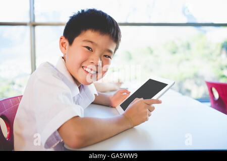 Schoolkid using digital tablet in classroom Stock Photo