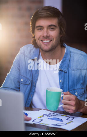 Young businessman having coffee in office Stock Photo