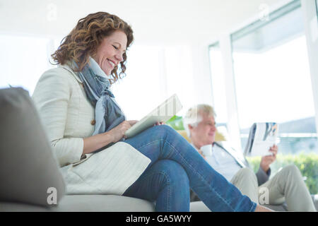 Smiling mature woman by man using digital tablet Stock Photo