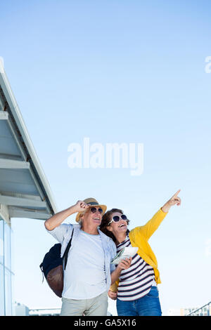 Woman with man pointing against clear sky Stock Photo