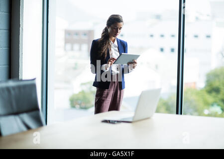 Focused woman using digital tablet in office Stock Photo