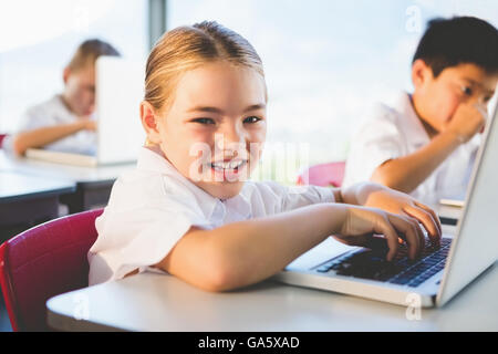 Schoolkids using laptop in classroom Stock Photo