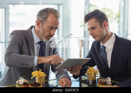 Businessmen using digital tablet in restaurant Stock Photo