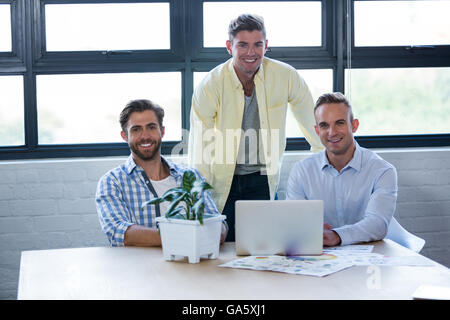 Confident creative businessmen by table Stock Photo