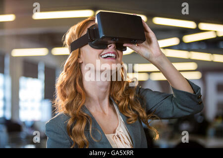 Smiling businesswoman using virtual reality simulator Stock Photo