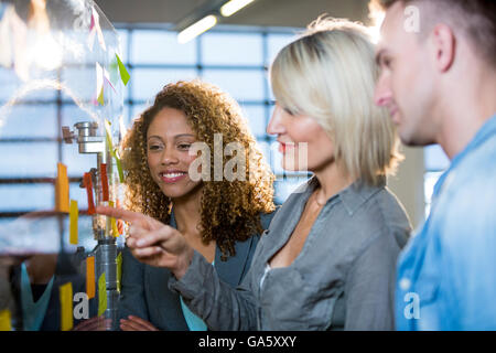 Businesswoman explaining colleagues over adhesive notes Stock Photo