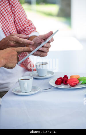 Midsection of man with friend using digital tablet Stock Photo