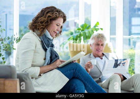 Mature woman by man using digital tablet Stock Photo