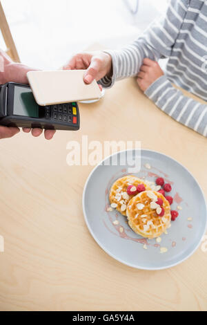 Woman making payment through NFC Stock Photo