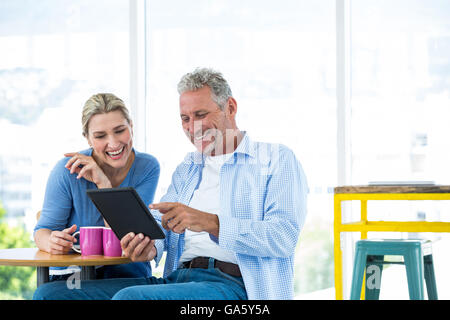 Smiling mature couple using digital tablet at restaurant Stock Photo