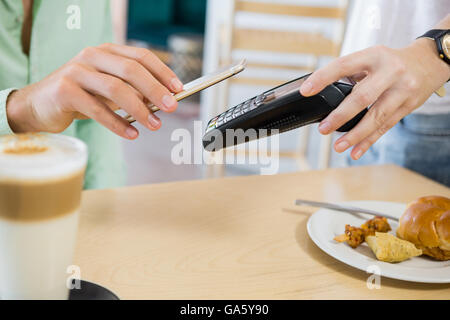 Customer making payment through smartphone Stock Photo