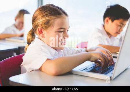 Schoolkids using laptop in classroom Stock Photo