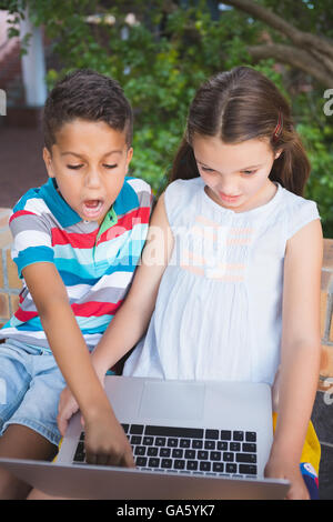 Schoolkids using laptop in school campus Stock Photo