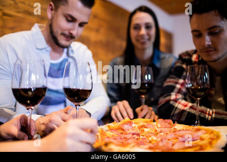 Friends enjoying pizza and wine Stock Photo