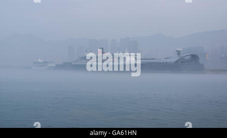 Cunard cuise ship Queen Mary 2 mooring in dense fog at the Hong Kong Kai Tak Cruise Terminal. Stock Photo