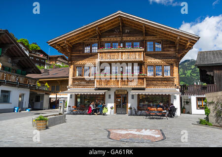 Chalet with a cafe on the main square of Saanen, a village in the Swiss Alps. Saanen, Berner Oberland, Switzerland. Stock Photo