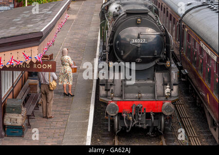 a 1940's man and woman on the platform of a steam railway Stock Photo