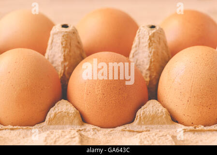 Six chicken eggs in cardboard box, retro toned, selective focus Stock Photo