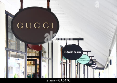 Signs outside a row of designer-label shops in Cheshire Oaks shopping outlet,  England. Stock Photo