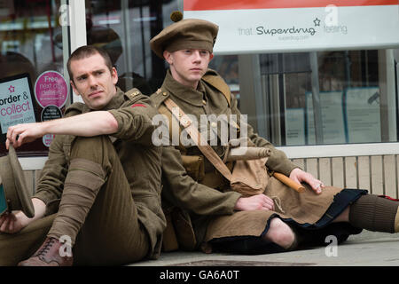 Young men dressed in First World War uniforms in Aberystwyth Wales as part of a UK-wide project to commemorate the Battle of the Somme, which started on this day exactly 100 years ago.   Across the UK some 2000 men are appearing in silent tableau on the streets of towns  handing  out cards with the name and regiment of the soldier they represented  and his age when he died on 1 July  1916  Commissioned by 14-18 NOW, the UK’s arts programme for the First World War centenary, the work was conceived by Turner Prize-winning artist Jeremy Deller with Rufus Norris, Director of the National Theatre. Stock Photo