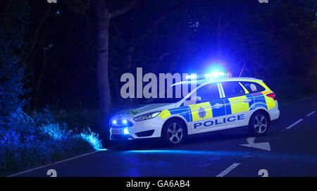 Police Car Blocking Road With Blue Lights On Stock Photo