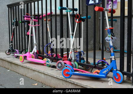 Kids roller scooters parked in the city Stock Photo
