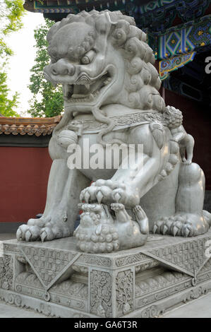 A stone chinese lion statue standing on a smaller one in the entrance to Jingshan Park in Beijing China. Stock Photo