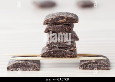 Dark cooking chocolate pieces arranged on wooden toothpicks with copy space Stock Photo