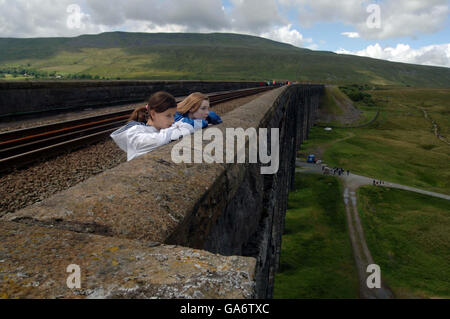 Taissia Froidure and Lauren Barker, along with hundred's of other people make the most of today's once in a life time opportunity to walk across the Ribblehead Viaduct on the Carlisle to Settle Rail-line in Cumbria. Stock Photo